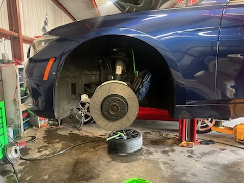 Vehicle on a lift with wheel removed for brake service