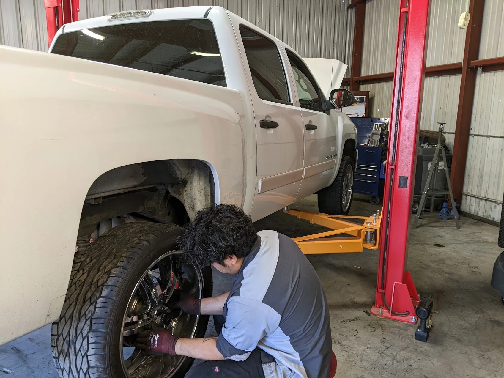 Mechanic servicing a white pickup truck